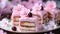 A piece of cake with pink frosting and cherry blossoms, spring petit four cakes.