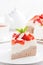 Piece of cake with whipped cream, strawberries and tea, vertical