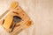 A piece of cheese with cinnamon sticks and allspice and a metal grater on a bamboo cutting Board and two bamboo spatulas with