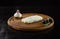 Piece of cheese with mold, garlic and olives on wooden board