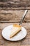 Piece of cheesecake with cake server on wooden table