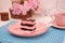 Piece of chocolate cake on pink plate as a background