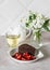 Piece of chocolate cake, strawberries and green tea on a light background. Delicious breakfast or snack