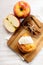 Piece of cinnamon apple pie on a wooden board with fresh apple in background, autumn food concept