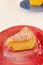 A piece of delicious carrot pie on a red shiny plate. Part of a homemade cupcake on a plate. Homemade pie on a ceramic plate on a