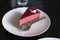 Piece of famous Poppy seed cake with raspberry mousse of Austrian origin served with whipped cream and cup of coffee