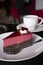 Piece of famous Poppy seed cake with raspberry mousse of Austrian origin served with whipped cream and cup of coffee