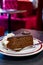 Piece of famous Sachertorte chocolate cake with apricot jam of Austrian origin served with whipped cream