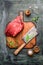 Piece of fresh beef meat on chopping board with meat cleaver large and seasoning on rustic background