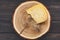 Piece of gouda herb cheese on natural wood disc