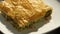 A piece of Greek style spanakopita or spinach pie in phyllo pastry