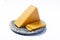 Piece of hard orange Cheddar cheese on grey stone plate isolated close up
