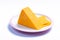 Piece of hard orange Cheddar cheese on white board isolated close up