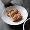 A piece of homemade oatmeal pie on a white plate on a black wooden table, a fine healthy tomorrow