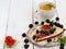 A piece of homemade pie with figs and blackberries is located on a vintage plate. Wooden vintage background. Next to the