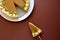 Piece of homemade pumpkin pie with cinnamon on brown paper background