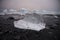Piece of ice in Iceland, iceberg, black beach sand