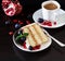 Piece of layer cake with fresh blueberries, cream cheese and chocolate cookies. Dark wooden background. Romantic Valentine`s Day