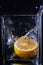 Piece of lemon in a glass vessel. Black background