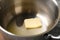 Piece of melting butter in pot