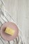 Piece of Napoleon Cake on pink plate over white wooden surface, overhead view. Flat lay, from above