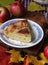 Piece of the pie, autumn leaves and red apples on the table with