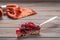 Piece of pie with berries: raspberries, currants, strawberries on the shovel on wooden background, in the background