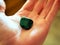 Piece of polished malachite in palm of hand.