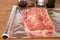 Piece of raw meat on aluminium foil sheet for baking. Cooking pork