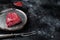 Piece of raw rump steak prepared for cooking. Black background. Top view. Copy space