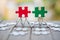 Piece of Red and green  jigsaw puzzle On the old wood And green background. teamwork concept.  symbol of association and