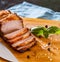 Piece of roasted pork belly on wooden cutting board