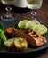 A piece of roasted salmon grilled lemon pepper and salt on a dark plate with broccoli. Wood background