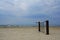 A piece of rusty destructed fence abandoned in the sand on a seaside.