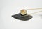 a piece of shushi with chopsticks in white background