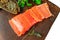 Piece of smoked fresh salmon with lettuce leaves on a ceramic Board