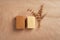 Piece of soap with ruffle carton box and dry herbs on rustic natural paper