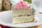 Piece of sponge cake with curd cream and banana, decorated cream meringue