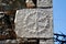 Piece of stone with sculptured symbol, detail from the exterior wall of an old house at Messiniaki Mani region in Peloponnese,