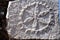 Piece of stone with sculptured symbol, detail from the exterior wall of an old house at Messiniaki Mani region in Peloponnese,