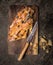 Piece of Sweet Braided Bread with raisins and roasted almonds on cutting board with knife