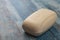 A piece of toilet soap on a wooden background. Close up. Purely washed hands to prevent the infection from COVID-19