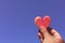Piece of watermelon in shape of heart in male`s hand against summer sky. Copy space