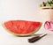 Piece of watermelon on white table with knife. Juicy refreshing summer food