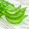 Pieces of aloe vera with pulp on a wooden background.Aloe vera essential oil or serum with sliced Aloe vera.skin care and hair