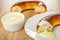 Pieces of baranka with poppy, bowl with sweet condensed milk, bread rings poured condensed milk in plate on table