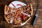 Pieces of barbecue pizza and red chili peppers in a white plate next to a cheese knife