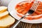 Pieces of bread, fork on jar with salted pink salmon  on plate on wooden table