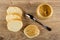 Pieces of bread, peanut butter in plastic jar, spoon, sandwich with peanut butter on table. Top view