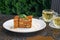 Pieces of cake and two glass cups of mint tea. Medovik cake on a table in a summer cafe. Tea drinking concept, Russian culture.